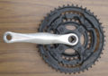 This is a cheap mountain crank. The chainrings are steel and they are riveted together. They look sort of like they might be bolted using allen bolts, but an inspection of the back of the crank lets you know that they are not.